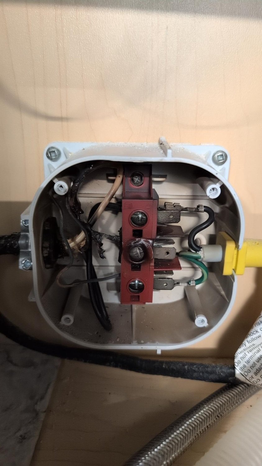 Opened dishwasher junction box with melted insulation and charred wiring at the supply terminal block
