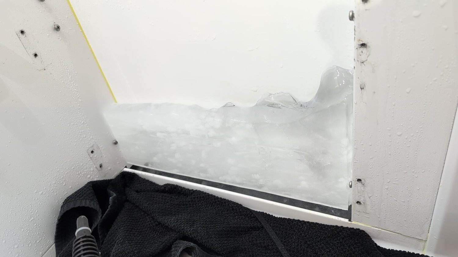 Thick sheet of ice built up across the rear wall and floor of the fresh food compartment of a Bertazzoni refrigerator in Stittsville