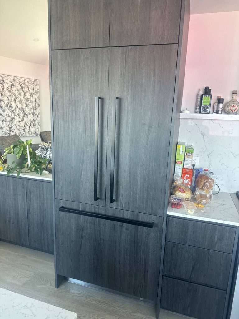 Panel-ready Fisher & Paykel built-in refrigerator finished in custom wood cabinetry in an East Vancouver kitchen